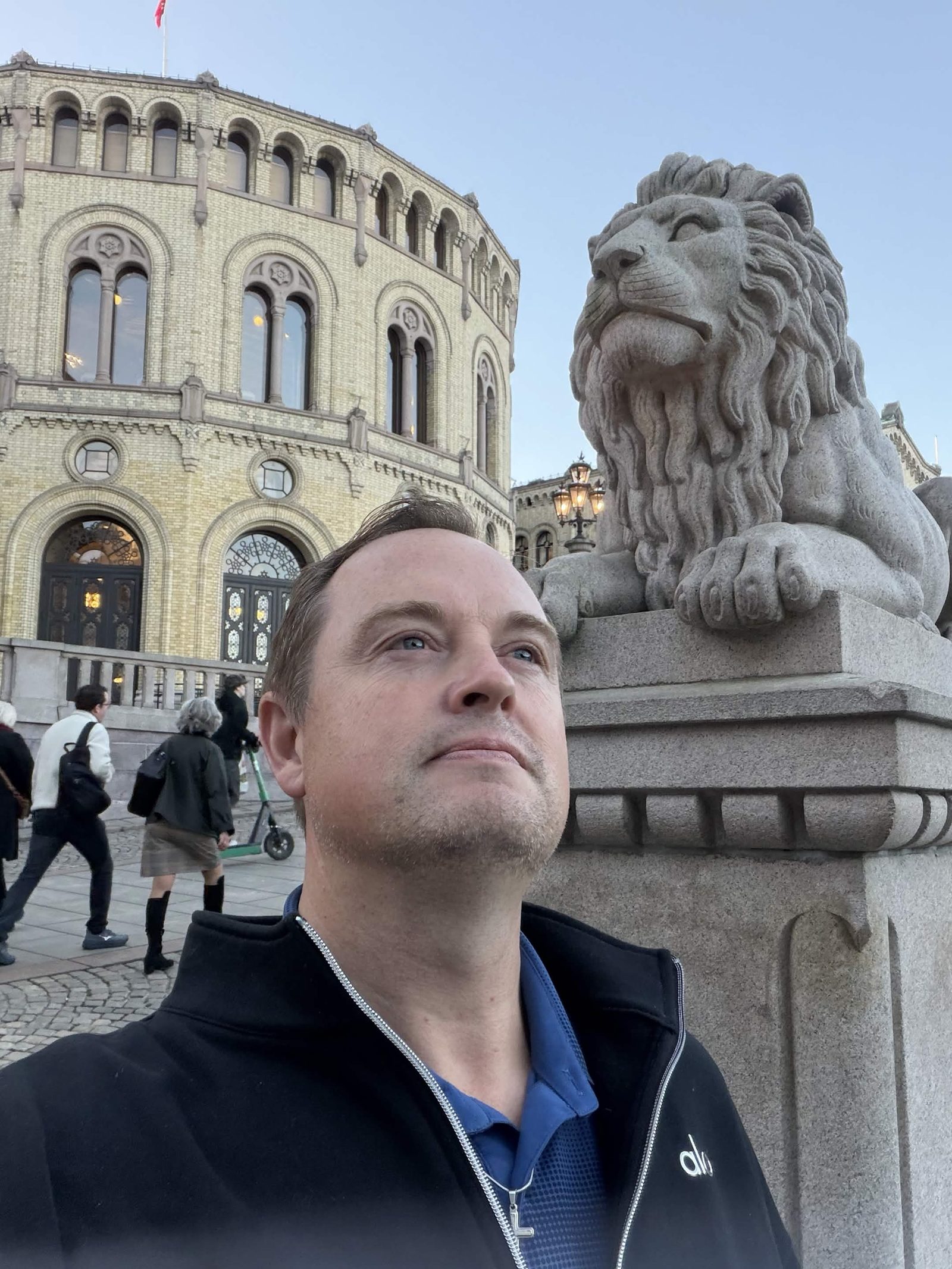 Oslo. The stone lion at the Storting, and a man who is not the monument.